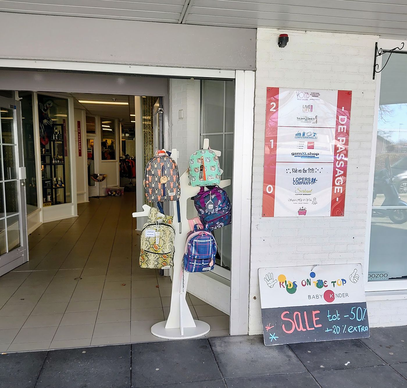 De ingang van Kids on the Top in De Passage, met rugzakken en het stoepbord